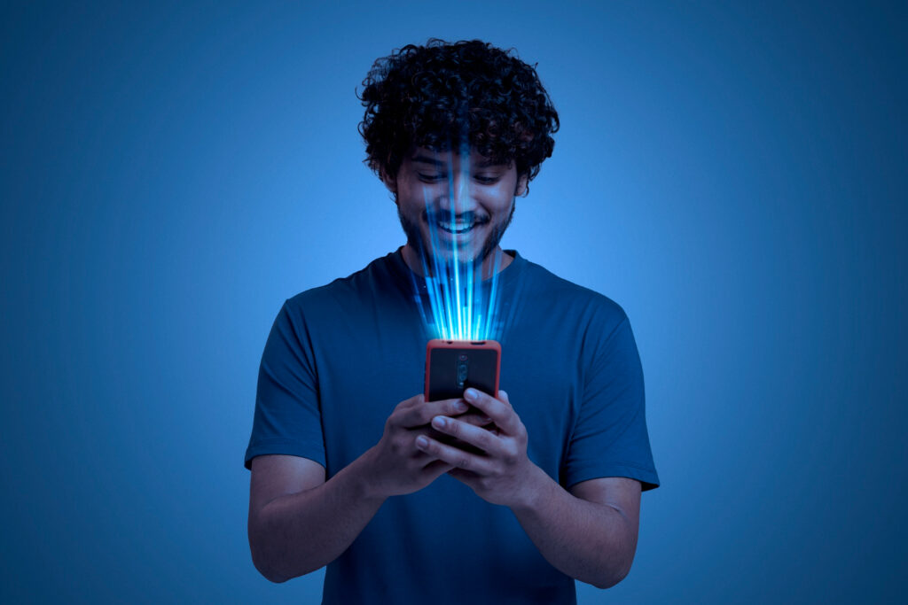 Um homem segurando um telefone, com uma luz saindo do telefone, ele está sorrindo com a melhora no seu atendimento e no aumento de vendas com nosso sistema